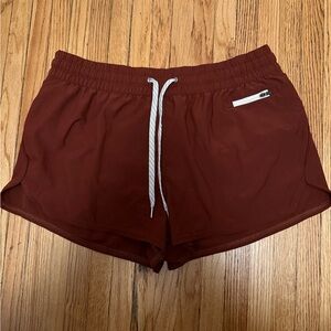 Vuori Women's Athletic Shorts in Rust Red